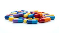 Colorful pharmaceutical capsules scattered on white background. Medical pills in various bright colors for healthcare and medicine concepts.
