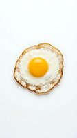 Fried egg with golden yolk and crispy brown edges on white background, isolated and ready for food, cooking, and breakfast design projects.