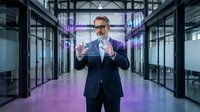 Middle-aged Caucasian male businessman in formal navy suit and glasses gesturing confidently in modern server room with purple neon lighting, suitable for tech, corporate, and business concepts.