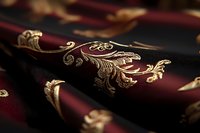 Luxurious burgundy fabric with ornate gold floral embroidery pattern creates elegant texture and depth, suitable for high-end fashion and interior design projects.