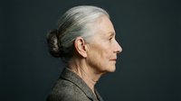 Senior woman with gray hair in profile, wearing neutral toned clothing against dark background. Suitable for healthcare, aging, wellness and lifestyle editorial use.