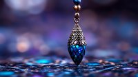 Ornate vintage pendant with blue crystal teardrop and intricate silver filigree detail against blurred bokeh background in magical turquoise and purple tones.