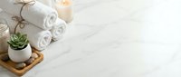 Spa wellness setup with rolled white towels, burning candles, succulent plant on wooden tray creating peaceful relaxation atmosphere for self-care rituals.
