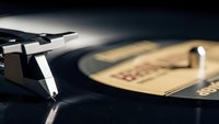 Vintage turntable with vinyl record playing, close-up of stylus and tonearm in warm lighting for music production and audio equipment concepts.