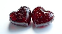 Two glossy red heart-shaped objects with translucent crystal-like surface reflecting light, symbolizing romance and love, placed against white background.