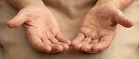 Open cupped hands gesture showing palms in receiving or giving position, symbolizing help, support, care, generosity and human connection.