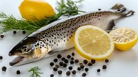 Fresh raw salmon fish with lemon slices, dill, and black peppercorns on white background, ready for cooking healthy seafood dish.