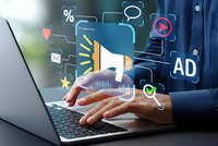 Digital marketing concept with businessman hands on laptop and floating megaphone icon surrounded by advertising symbols and communication elements.