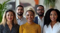 Diverse professional team of young adults smiling in modern office with plants. Business colleagues portrait for corporate teamwork and collaboration.