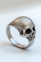 Silver skull ring with detailed anatomical features on light background, showcasing gothic jewelry design and metalwork craftsmanship for alternative fashion accessories.