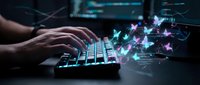 Hands typing on illuminated keyboard with glowing digital butterflies emerging from screen in dark tech environment for creative design projects.