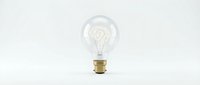 Vintage incandescent light bulb with glowing filament on clean white background, isolated for creative design projects and energy concepts.