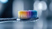 Rainbow colored toothbrush bristles on transparent handle against blurred background for dental hygiene and oral care concepts.