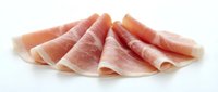 Thin sliced prosciutto ham arranged on white background, isolated deli meat for culinary designs and food photography projects.