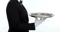 Professional waiter in black uniform holding silver serving tray with white gloves against clean white background for hospitality service concepts.