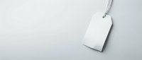 White blank price tag with string on light gray background, isolated mockup template for retail branding and product labeling design projects.