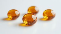 Amber colored gel capsules or vitamin supplements on white background for health and wellness marketing materials.