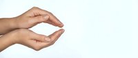 Two cupped hands in protective gesture on white background, symbolizing care, support and safety for healthcare and insurance concepts.