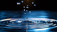 Single water drop falling into calm surface creating concentric ripples with floating droplets above, captured in dramatic blue lighting against dark background.