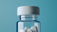 White round pills in transparent prescription bottle with ribbed cap against turquoise background, minimalist pharmaceutical composition for healthcare concepts.