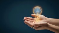 Young woman's hands holding glowing light bulb with digital brain circuit pattern against dark blue background, symbolizing innovation, creativity, and smart ideas for business solutions.