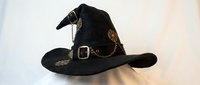Black witch hat with golden buckle and chain decorations for Halloween costume party celebration on white background isolated for design use.