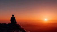 Silhouette of person meditating on mountain peak during golden sunset with warm orange and pink sky colors creating peaceful spiritual atmosphere.