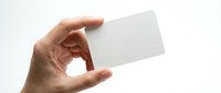 Hand holding blank white business card mockup against clean background for branding and corporate identity design projects.