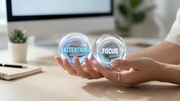 Hands holding two transparent spheres with attention and focus text, representing concentration and mindfulness concepts for business and productivity themes.