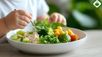 Hands holding fork over fresh healthy salad bowl with mixed greens, cherry tomatoes, quinoa and vegetables on wooden table for nutritious meal.
