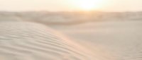 Soft golden sand dunes with gentle ripples in warm desert landscape during sunset creating peaceful natural texture for meditation and wellness concepts.