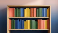 Colorful books arranged on wooden bookshelf with rainbow spectrum organization creating vibrant library display for educational and reading concepts.