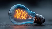 Glowing vintage Edison light bulb with bright orange filament coil against dark background. Energy efficiency concept for creative projects and designs.
