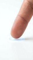 Close-up macro shot of human fingertip showing detailed skin texture and fingerprint patterns on clean white background for medical and identity concepts.