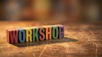 Colorful wooden letter blocks spelling WORKSHOP on rustic wood surface with warm bokeh background for business training and educational concepts.