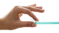 Close-up of hand holding turquoise toothbrush against white background. Isolated dental care product for healthcare, hygiene, and wellness design projects.