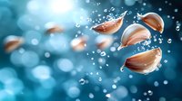 Floating garlic cloves with water drops and bubbles on turquoise blue bokeh background. Artistic food photography with dramatic lighting and motion effect.