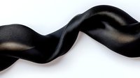 Elegant black silk ribbon flowing in smooth waves against white background, perfect for luxury packaging, fashion design, and decorative projects.