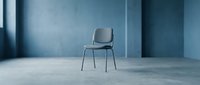 Single modern chair with metal legs positioned in minimalist concrete interior space with blue-toned walls, suitable for furniture design, interior styling, and contemporary decor projects.