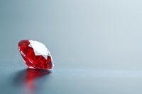Brilliant red ruby gemstone on gray background with soft reflection and copy space. Luxury jewelry concept with dramatic lighting and minimalist style.