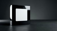 Modern black acrylic display stand with white blank card for product presentation and branding mockup on dark surface.