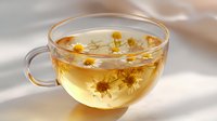 Aromatic chamomile tea in transparent glass cup with fresh chamomile flowers floating on surface, soft natural lighting creates gentle shadows and warm ambiance.