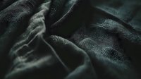 Dark green velvet fabric with elegant pattern and soft folds creating luxurious textile background with deep shadows and rich texture for design projects.
