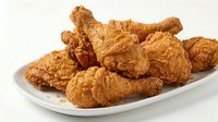 Crispy fried chicken pieces served on white plate, golden brown coating, ready for fast food restaurant menus, catering, and food photography.