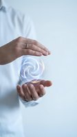 Hands protecting glowing energy sphere with swirling light patterns symbolizing innovation, protection, and digital transformation in business.