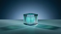 Translucent turquoise glass cube with metallic accents casting shadows on reflective surface against blue gradient background. Suitable for technology, innovation, and corporate design projects.