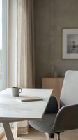 Minimalist home office workspace with modern chair, white desk, coffee mug and notebook near window with natural light for productivity and remote work.