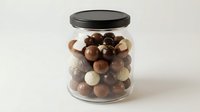 Glass jar filled with assorted chocolate truffles and candies with dark lid on white background isolated for confectionery and dessert designs.