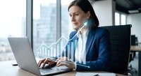 Professional businesswoman working on laptop with financial growth charts and data analytics in modern office environment for corporate success.