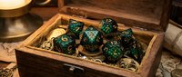 Polyhedral dice set with green and gold swirled pattern displayed in wooden box for tabletop gaming and role-playing campaigns.